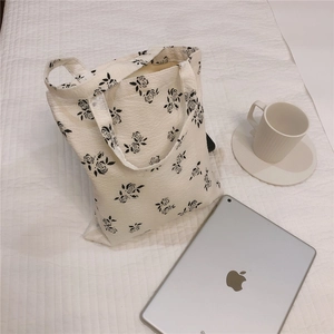 Detail of floral quilted cotton tote bag with abstract black roses on white fabric