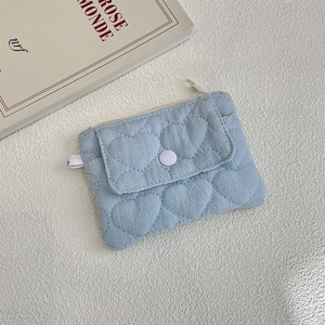 Detailed view of light blue quilted heart coin purse with snap pocket and zipper top