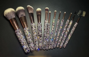 Detail of 12-piece sparkling rhinestone handle makeup brushes set on black background