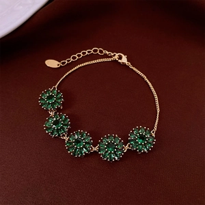 Détail du bracelet plaqué or 18 carats avec fleurs en zircon vert émeraude