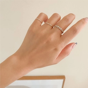 Detailed view of layered 925 sterling silver rings with minimalist and chain textures