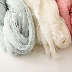Detail of soft cotton linen scarves showing delicate texture and fringe in pastel tones
