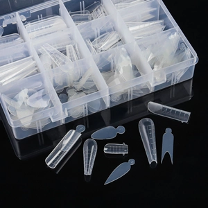 Detailed view of clear nail extension molds set in storage box for professional manicure
