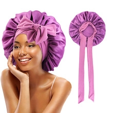 Detail of purple satin sleep cap featuring a large decorative bow and adjustable ribbon ties