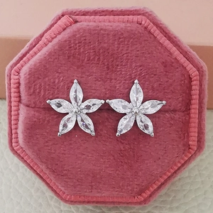 Detailed macro view of zircon butterfly earrings in a pink velvet jewelry box