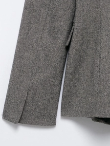 Detail shot of textured grey fabric on blazer cuff and pocket flap stitching