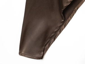 Close-up of brown satin top showing precise stitching and smooth silk fabric texture