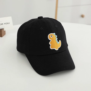 Détail de la broderie de dinosaure jaune sur une casquette de baseball noire enfant