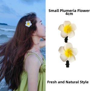 Detail of 4cm small frangipani hair clip set with white petals and yellow centers