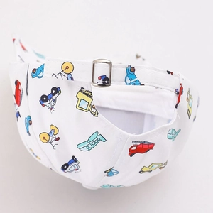 Detail van de witte kinderpet met cartoon voertuigenprint en een metalen gesp sluiting