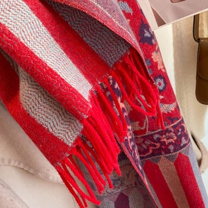 Close-up of ethnic floral pattern and soft red tassels on thick pashmina shawl