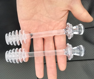 Gros plan de deux cuillères à miel transparentes avec têtes en spirale tenues à la main