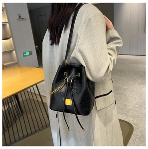 Dettaglio borsa a secchiello nera con logo JEY.DS dorato e chiusura a coulisse