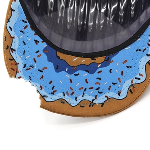 Detail of baseball cap brim featuring doughnut print and unique bite-mark cutout design