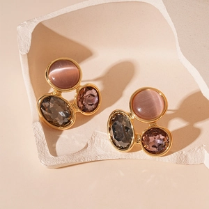 Détail des boucles d'oreilles en œil-de-chat multicolore sur un support en pierre
