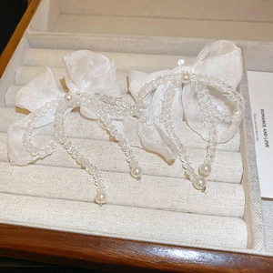 Détail de nœuds à cheveux blancs élégants avec glands de perles sur fond de velours