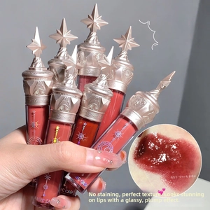 Detail showing various glossy lip glaze shades with gold star caps and brand logos
