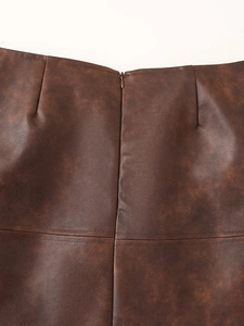 Vue détaillée de la texture du similicuir marron avec fermeture éclair et coutures fines