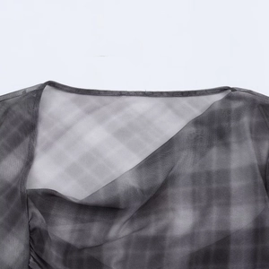 Detailed view of grey and black gradient mesh fabric texture on the asymmetric plaid top
