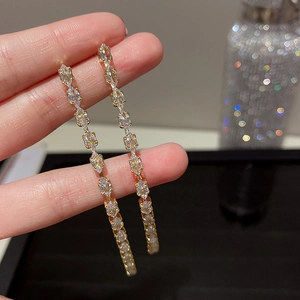 Vue rapprochée de boucles d'oreilles pendantes dorées avec cristaux brillants marquise