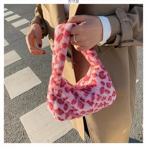 Close-up of pink and red leopard print plush handbag during an outdoor street photoshoot