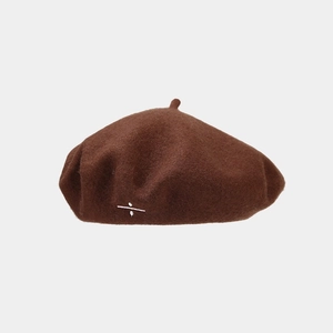 Détail du béret en laine marron foncé avec broderie du signe de division blanc sur le côté