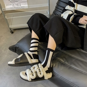 Classic black and white faux fur-lined leather mules with double metal buckles for women