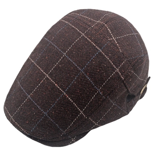 Detail of dark brown herringbone flat cap with colorful plaid pattern and metal side buckle