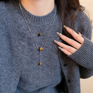 Detail of silver double-layer tiger eye stone necklace worn on neck for women