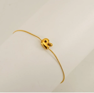 Detailed close-up of a luxury gold chain bracelet featuring a polished letter R pendant