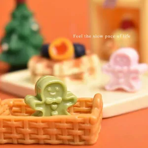 Miniature green gingerbread man resin figurine in a basket for Christmas DIY crafts