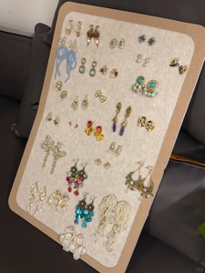 Macro shot of seashell tassel and beaded earrings collection on a beige velvet display board