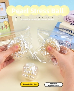 Detail of squeezing a transparent stress ball filled with shiny white faux pearls