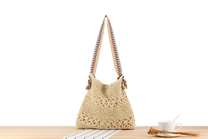 Close-up of woven straw bag with floral crochet pattern and colorful ethnic strap