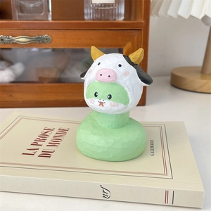 Détail d'une figurine en bois sculpté à la main représentant un personnage en vache