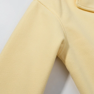 Detail of high-quality stitching and wool fabric texture on a yellow short coat