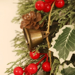 Decorazione natalizia da appendere con campane di bronzo bacche rosse e pigne