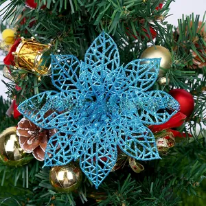 Blue glitter hollow poinsettia flower ornament attached to a decorated Christmas tree