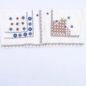 Elegant white V-neck blouse featuring intricate blue floral embroidery and cotton linen fabric