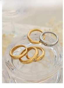 Detailed stack of 18K gold plated stainless steel rings with zircon star engravings