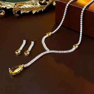 Detailed macro view of sparkling yellow teardrop zircon necklace and matching earrings