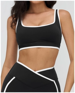 Detailed front view of women's yoga bra with contrast piping and high waist cross belt leggings