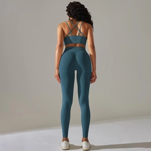 Detail of high-waisted teal yoga leggings and cross-back bra with ribbed knit fabric