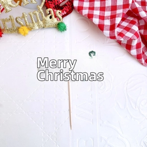 Detail of green Merry Christmas cake topper with wooden stick and reindeer motif