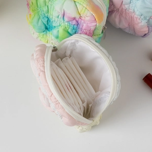 Close-up of quilted macaron tie-dye pouches with metal zipper showing interior capacity