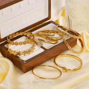 Elegant 18k gold plated stainless steel bangles set with zircons on yellow silk background