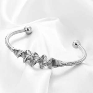 Silver twisted stainless steel cuff bracelet with double ball ends on silk background