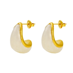 Macro detail of gold-plated stainless steel earrings with white resin teardrop inlays