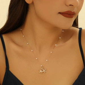Starfish pearl pendant necklace in 18K gold plated steel worn by a female model