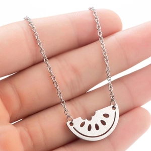 Minimalist stainless steel watermelon pendant necklace shown on hand for scale